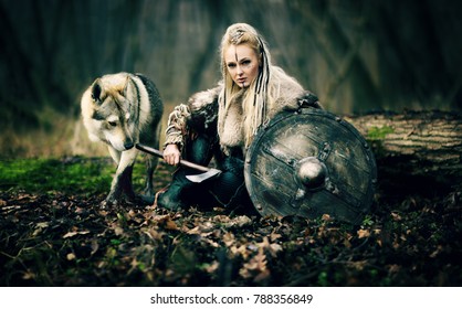 Warrior Woman  with a woolf in the woods. Viking girl. Reconstruction of a medieval scene