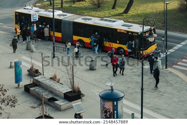 Warsaw. Poland. 03.30.2022. Elongated city\
bus at the bus stop. People get on the\
bus.