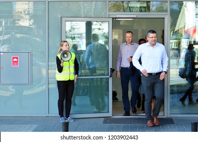 Warsaw, Poland. 15 October 2018. Evacuation of an office building. People exit the building on exit door.