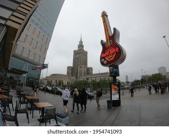 Warsaw, Poland - April 28, 2019 - Palace Of Culture And Science (PKiN) At Plac Defilad In Center Of Warsaw, Stalin's Gift For City Of Warsaw. Hard Rock Cafe Giant Guitar Logo.