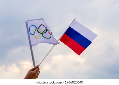 Warsaw, Poland - April 29, 2021: Fan Waving The National Flag Of 
Russia And The Olympic Flag.