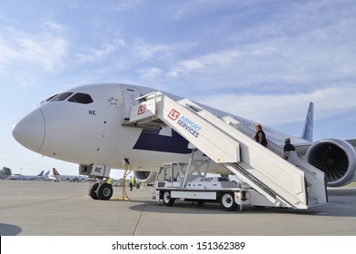 WARSAW, POLAND - AUGUST 4: Passengers board the LOT Polish Airlines Boeing 787 Dreamliner while crew prepare the aircraft for departure at Chopin Airport on August 4, 2013 in Warsaw, Poland.