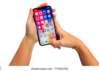 WARSAW, POLAND - DECEMBER 02: Two Hands Holding New Iphone X Mobile Phone With Apps Over White Background