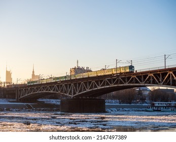 Warsaw, Poland - December 2021: The Cross-city Bridge, Railway bridge over the Vistula River, Train running on the bridge