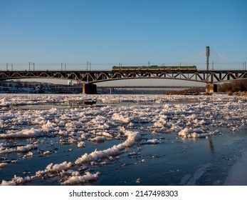 Warsaw, Poland - December 2021: The Cross-city Bridge, Railway bridge over the Vistula River, Train running on the bridge