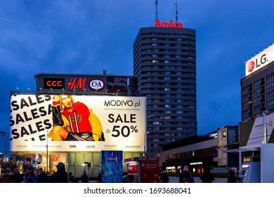 Warsaw, Poland - January 22, 2020: Cityscape Near Warszawa Centralna Central Railway Metro Station With Buildings At Night And Advertisement Sign For Shopping