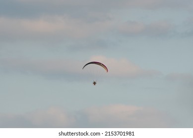 Warsaw, Poland - July 15, 2020: Paramotor flight at sunset. Active recreation with adrenaline. A paraglider in the air.