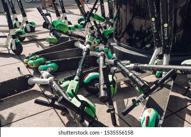 Warsaw, Poland - July 21, 2019: Many electric scooters, escooter or e-scooter of the ride sharing company LIME left on sidewalk in Warsaw, Poland