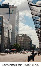 Warsaw, Poland - June 22, 2022: Street Traffic. Hotel Landmark. Downtown Industry. Busy City With Modern Skyscraper Road With Riding Cars Walking People In Sunny Daylight.