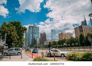 Warsaw, Poland - June 27, 2022: Cityscape View. City Architecture. Central District. Street With Diverse Buildings Parking Cars Walking People In Sunny Daylight.