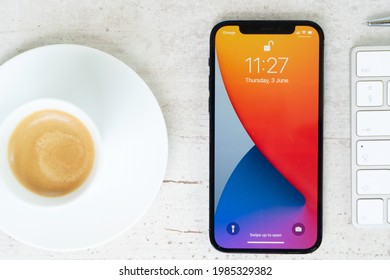 Warsaw, Poland - June 3, 2021: New IPhone 12pro On White Table With Cup Of Coffee, Top View Mock Up