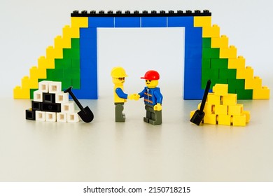 Warsaw, Poland - October 18th 2019: A team of Lego workers built a bridge. Concept of teamwork, success at work. The engineers congratulate themselves on the work they have done. Good job.
