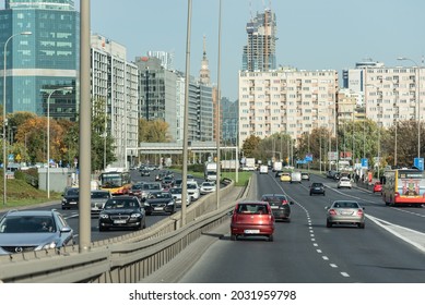 Warsaw, Poland - October 19, 2020: Road traffic in the city, center of Polish capital, skyscrapers and office buildings. Sunny day and cars on the road.