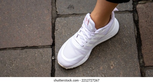 Warsaw Poland, October 2, 2022: Feet Wearing White Adidas Shoes. Girl Legs Wearing White Color Sneakers.  Women Wearing Adidas White Shoes