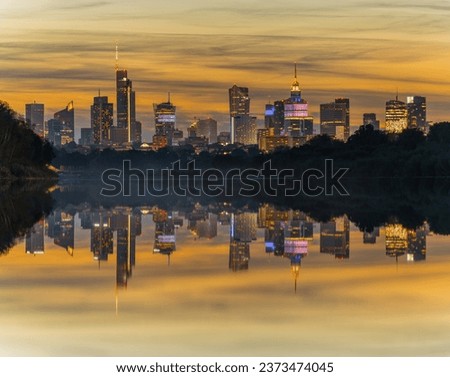 Warsaw urban skyline cityline panorama at autumn sunset. Reflection in the river 