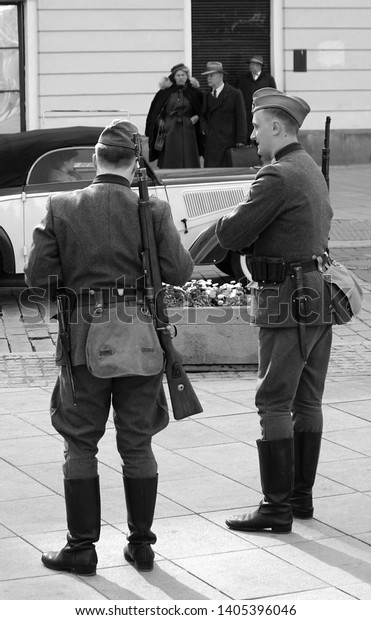 Warsaw/Poland - 5 May 2019: Retro movie scene with\
old-timer cars, bicycle and people on a street.  Shooting film in\
Warsaw, Poland. Times of War. Retro concept. Film making. Filming\
movie scene.     