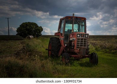 Warwick, Australia - January 10, 2017: An Old Red Tractor Sits In Farmland In Rural Queensland.