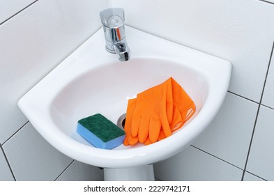 Wash basin for hands with protective rubber gloves and sponge.