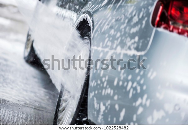 Wash car. Clean car at wash station\
with high pressure water and soap. Car washing\
detail.