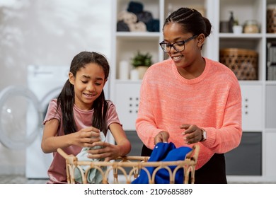 Wash Clothes In Washing Machine, Laundry Room, Bathroom, Two Women Spend Time Talking While Doing Household Chores, Mother Explains To Daughter, Teaches Her How To Sort Things By Color