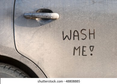 'Wash Me' Written On A Black Dirty Car