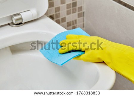 Wash the rim of the white toilet bowl with an antiseptic in protective gloves.