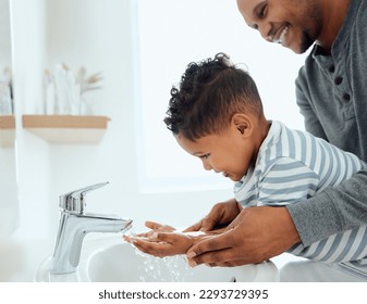 Wash them thoroughly. Shot of an adorable little boy washing his hands with the help of his father at home. - Powered by Shutterstock