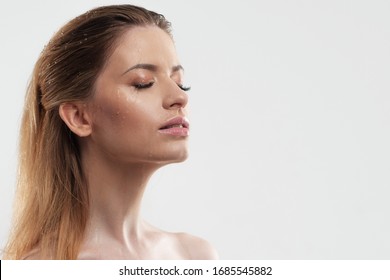 Wash your face and take care of your skin. Portrait of a young woman with beautiful clear skin, close-up on a white background. Skin care, copy space