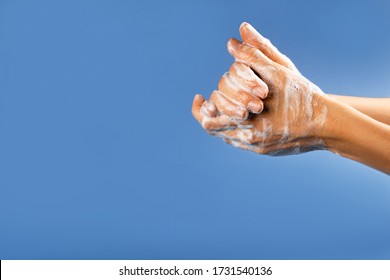 Wash Your Hand - Coronavirus Healthcare And Hygiene Concept. Photo Of Woman Hands With Soap Foam On Blue Background.