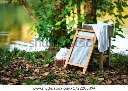 Washboard of the past. Hard labour. Laundry at the pond. Cleanliness, freshness, order. Basket with clean and ironed linen
