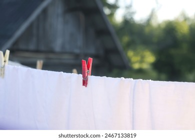 Washed clean textile and clothes drying on the rope outdoors. 
