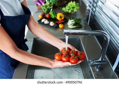  Washed tomatoes under running water in a professional kitchen. - Powered by Shutterstock