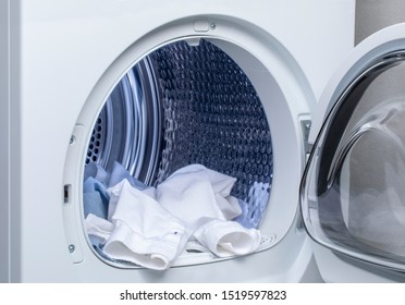 Washer And Dryer. Clothes Hanging From The Open Machine.