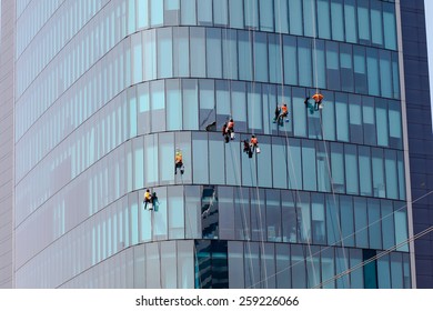 Washers wash the windows of modern skyscrape