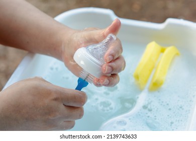 Washing baby nipples. Mother's hand washing the baby nipples