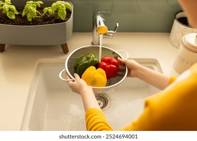 Washing bell peppers in colander under running water in kitchen sink. vegetables, health, fresh, clean, cooking, food preparation - Powered by Shutterstock