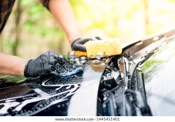 Washing\
the black car. Car cleaning and car care\
concept.