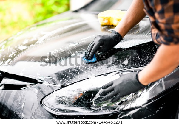 Washing\
the black car. Car cleaning and car care\
concept.