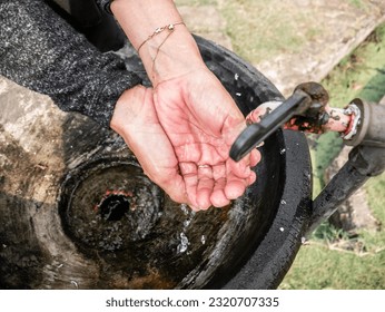 washing both hand with old tap water in the garden with gold bracelet on hand - Powered by Shutterstock