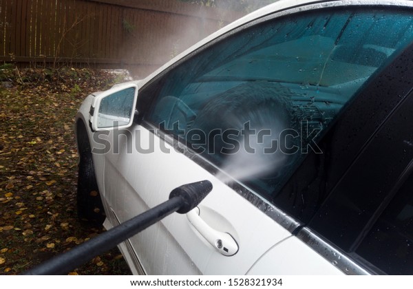 Washing a car in a
back yard, autumn scene