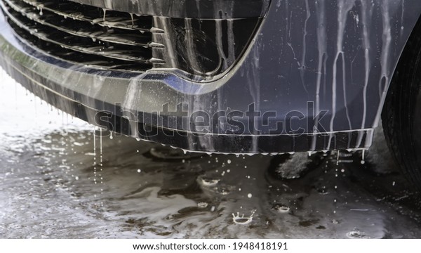 Washing car with hose and soap, mechanical\
workshop, vehicle\
maintenance
