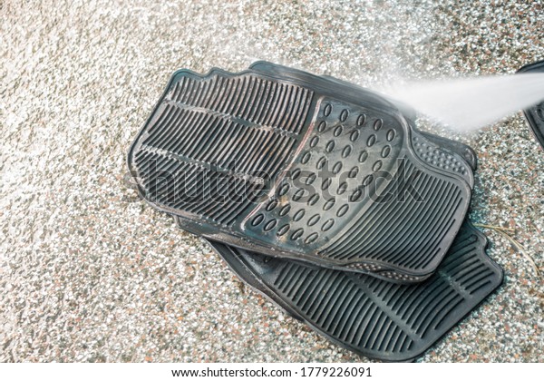 Washing\
car mats with high pressure water in car\
wash.