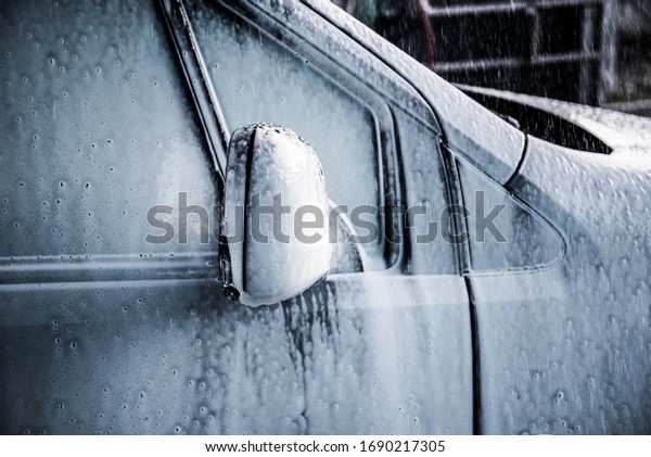 Washing car with soap. Close up clean car concept\
at car wash.