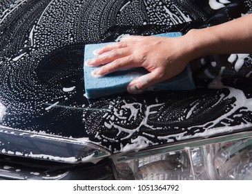 Washing a car with a sponge and soap