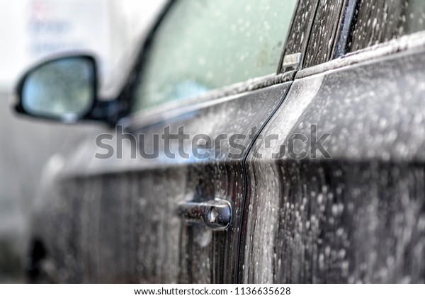 washing a\
car at the car wash with water and\
shampoo