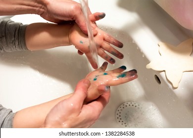 Washing child hands after playing with paint felt pen - Hygiene concept close up - Parent helping child to wash hands after coloring and playing with crayons - Powered by Shutterstock