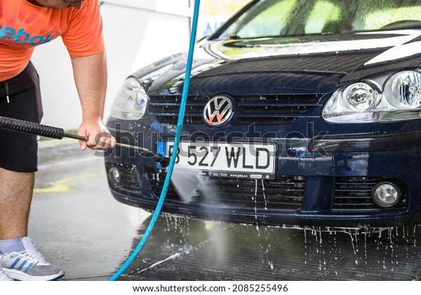 Washing and cleaning car in self service car wash\
station. Car washing using high pressure water in Bucharest,\
Romania, 2021