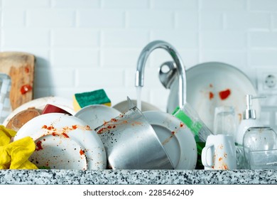 washing dirty dishes at home - Shutterstock ID 2285462409