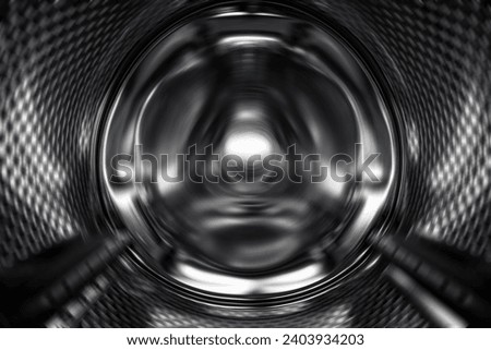 Washing Dryer Machine inside view during work. Drum of the washing machine rotates, view from the inside. Metal drum of a washing machine. Abstract home background. Inside of washing machine.