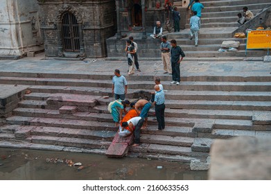 Washing the feet of the deceased - the rite of washing. The deceased must wash his feet before cremation. Preparation for cremation of the human body. Pashupatinath Temple. Nepal. 24.05.2011